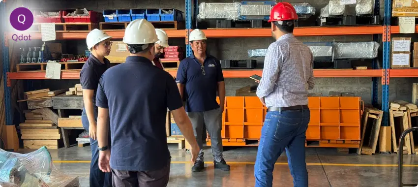 Qdot team performing a workplace evaluation and safety meeting in a warehouse environment
