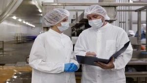 Food production managers discussing workflow and food safety controls during ISO 22000 implementation review