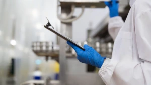 Food safety inspector holding checklist during ISO 22000 compliance review in Qatar