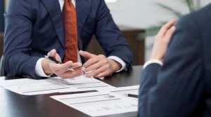 Business meeting reviewing tender documents to support ISO compliance and scoring in Qatar